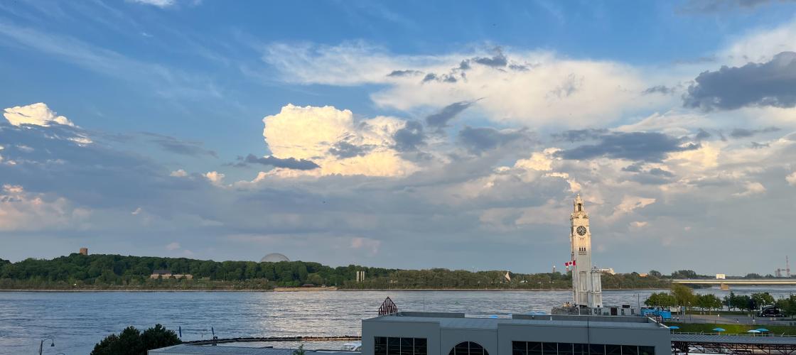 Vue paisible du fleuve Saint-Laurent, avec la tour de l’horloge se dressant fièrement au bord de l’eau Vue paisible du fleuve Saint-Laurent, avec la tour de l’horloge se dressant fièrement au bord de l’eau